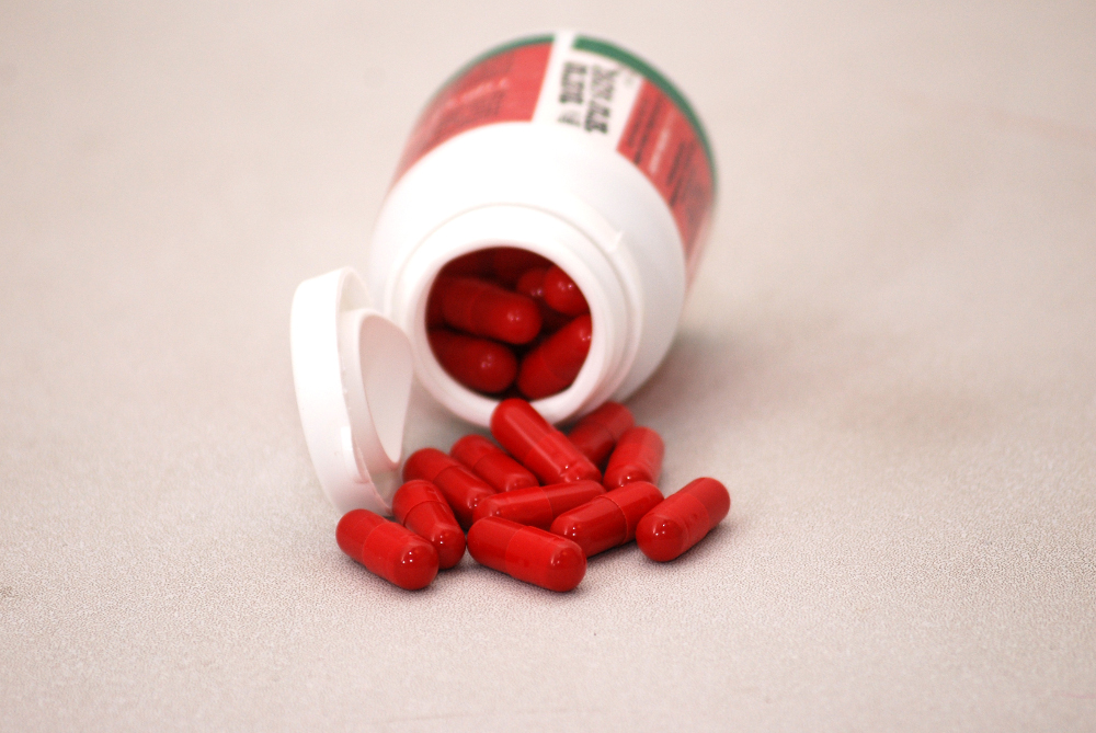 A bottle of pills dropped and some have been spilled out.