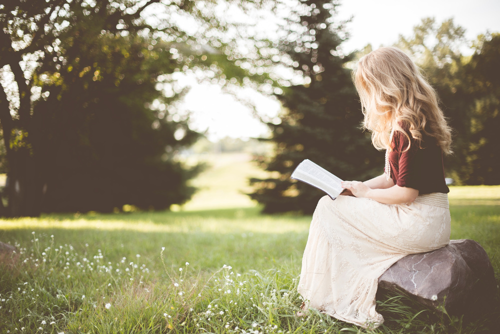 A woman reading a book in nature